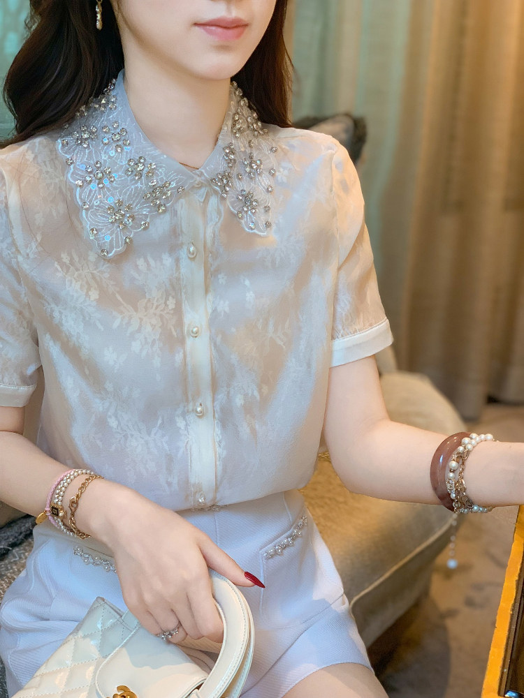 Woman wearing a light blue embroidered short-sleeve blouse with matching shorts