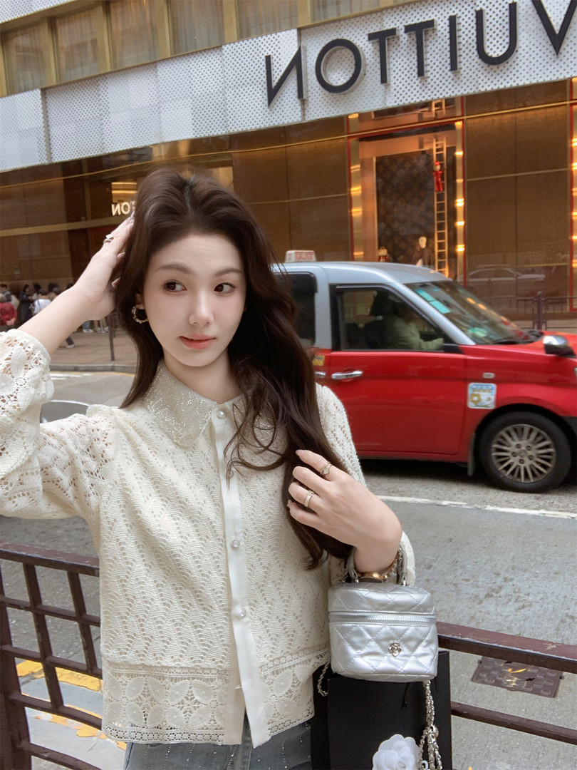 Woman wearing a cream lace cardigan and carrying a silver quilted mini bag