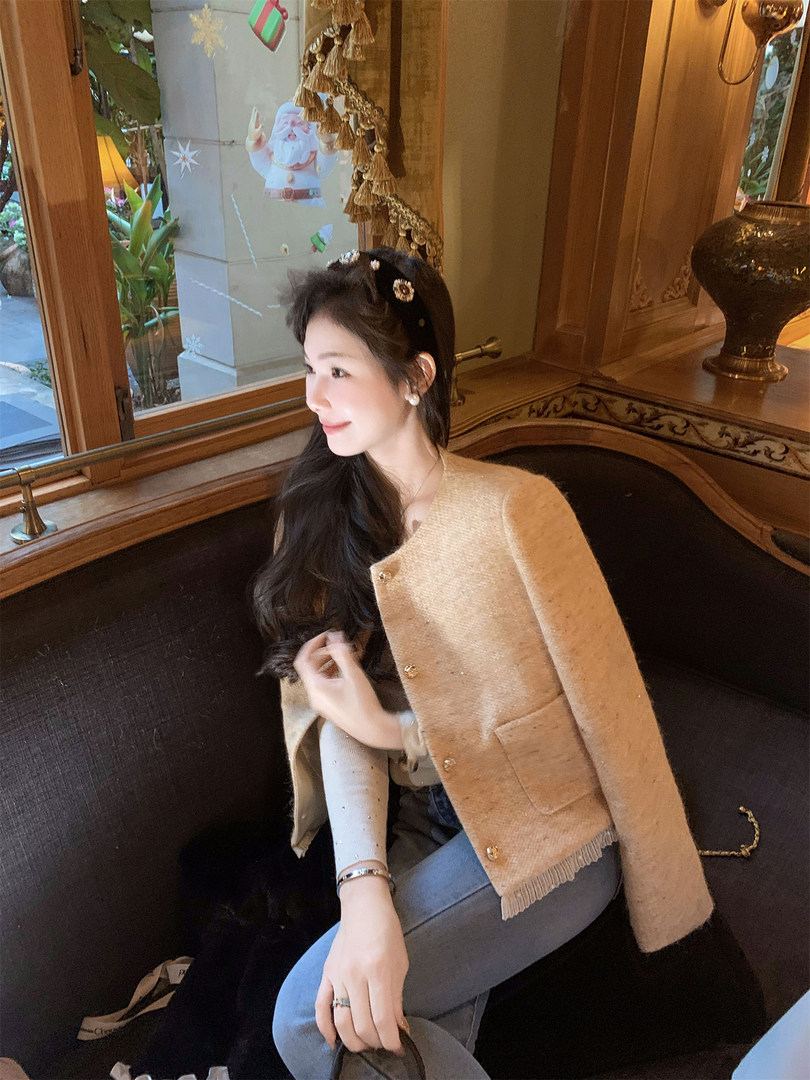 Beige textured cape-style jacket worn by a woman