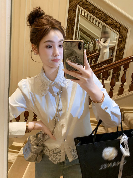 Woman wearing a white lace-collar blouse in a mirror selfie