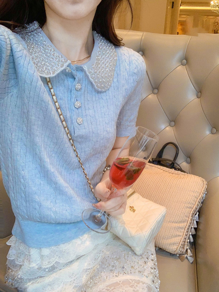 Light blue knit top with pearl collar worn by a model