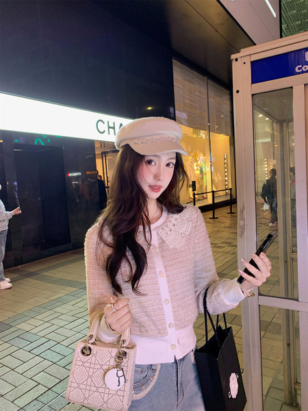 Woman wearing a pastel tweed cardigan outfit with a matching hat and handbag