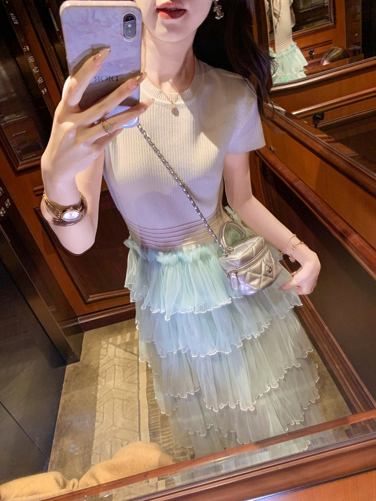 Woman wearing a ribbed short-sleeve top with a layered pastel tulle skirt and small crossbody bag in a mirror selfie