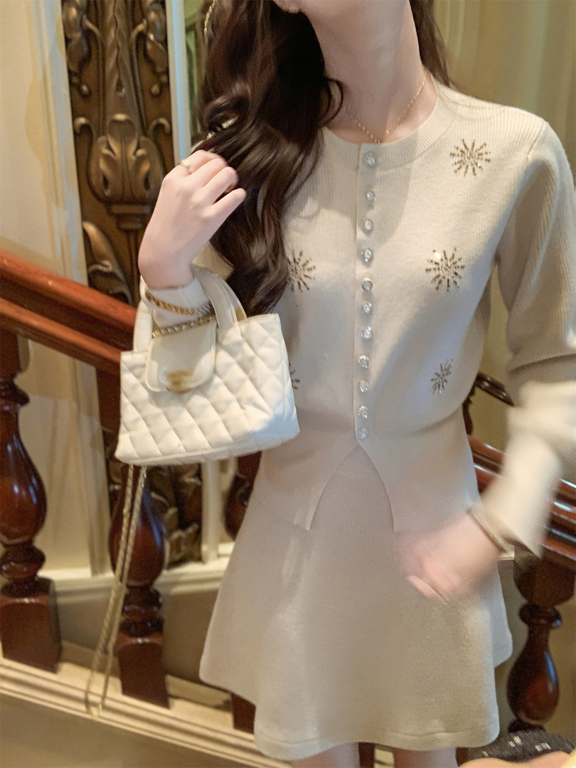 Cream knit cardigan and matching skirt set worn by a model, with a small quilted handbag