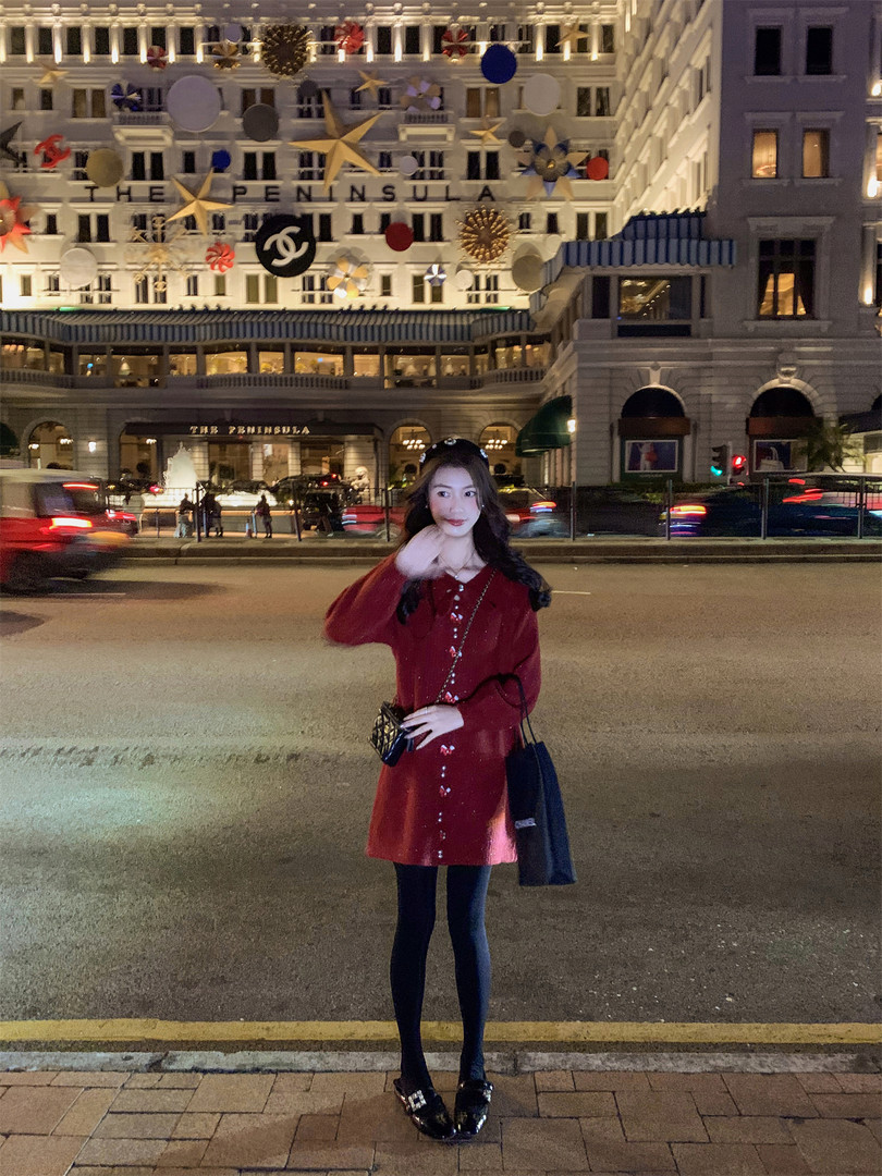 Woman wearing a red long-sleeve mini dress with black tights and loafers