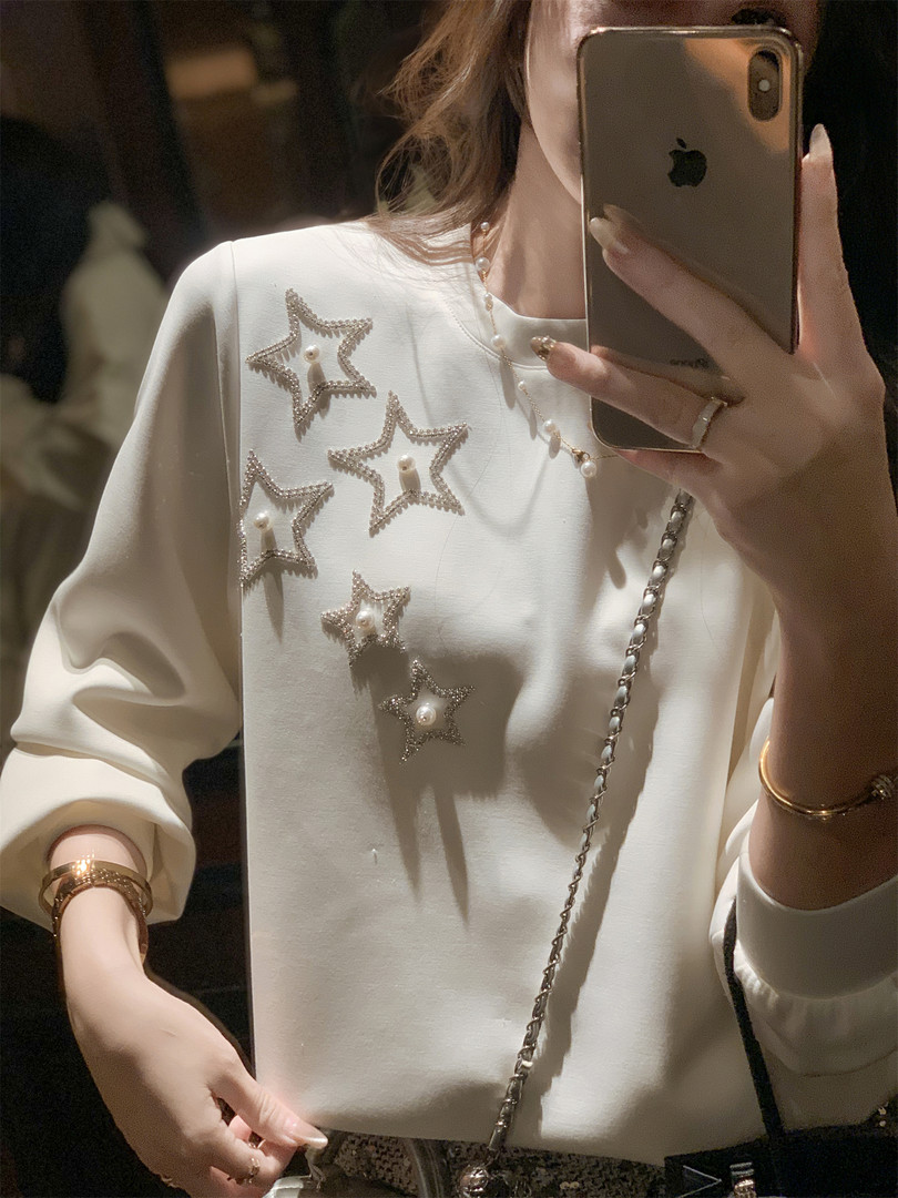 Cream long-sleeve top with embellished star details being worn in a mirror selfie
