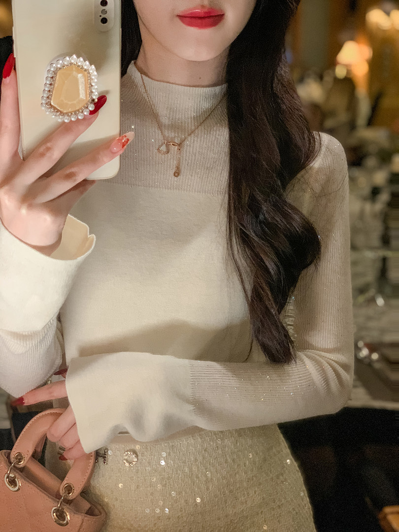 Woman wearing a cream long-sleeve knit top with a sparkly skirt