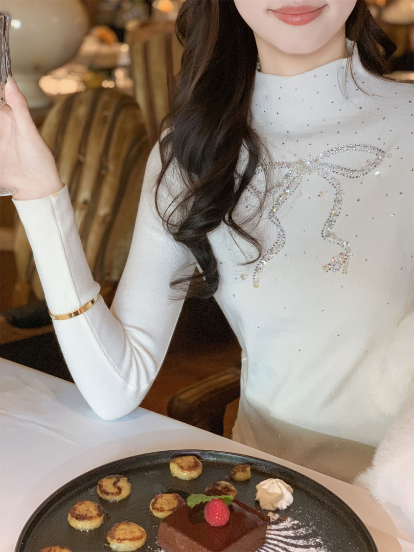 Woman wearing a white embellished long-sleeve fitted top
