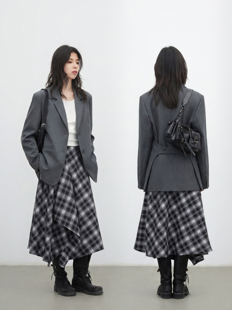 Gray blazer and plaid midi skirt outfit worn with black boots and a small shoulder bag