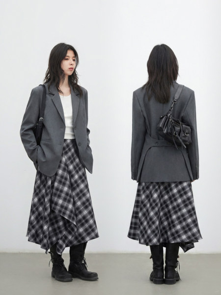 Gray blazer and plaid midi skirt outfit worn with black boots and a small shoulder bag
