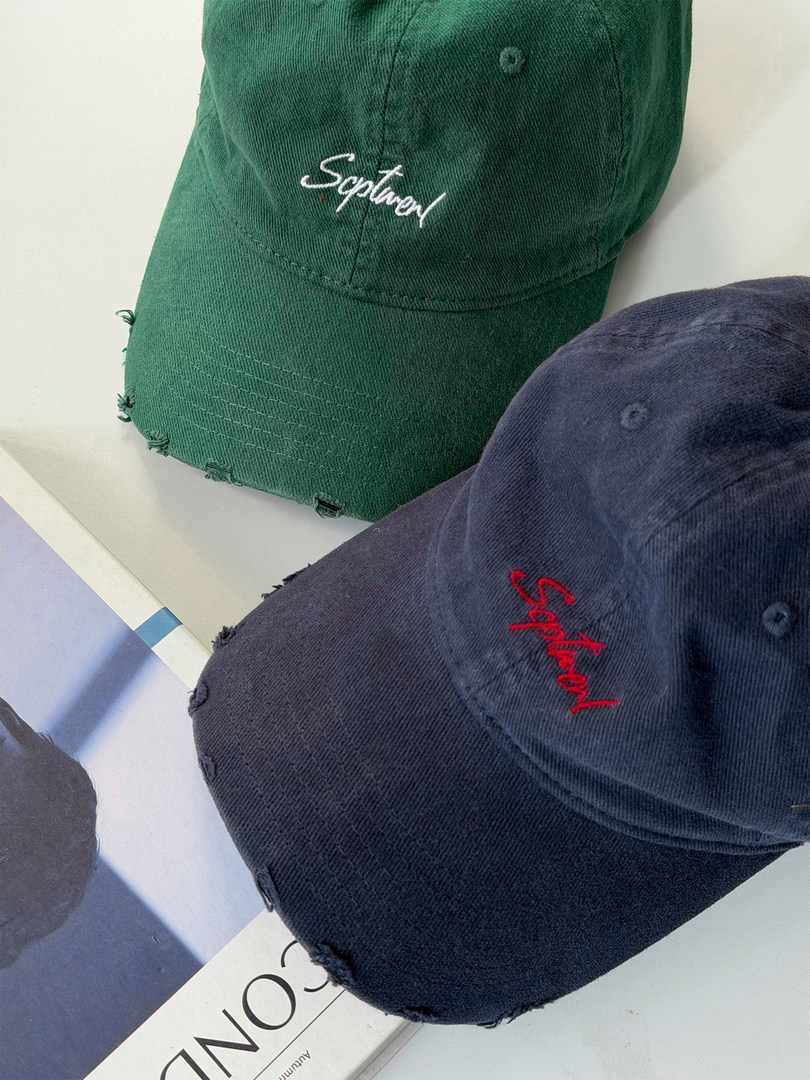 Distressed embroidered baseball caps in green and navy