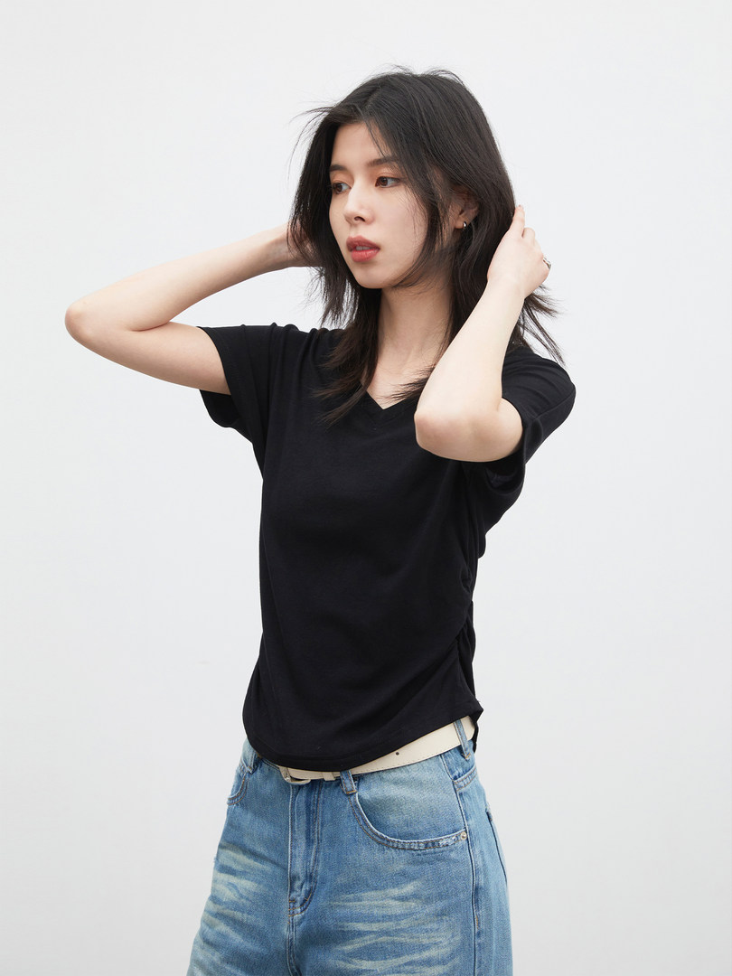 Black short-sleeve V-neck T-shirt worn with blue jeans on a model
