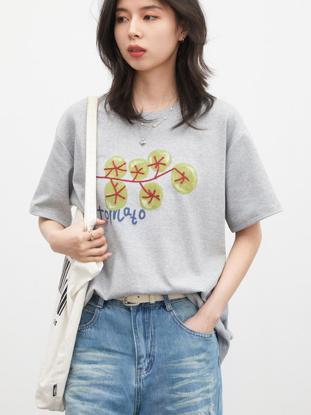Model wearing a gray graphic T-shirt with jeans and a tote bag