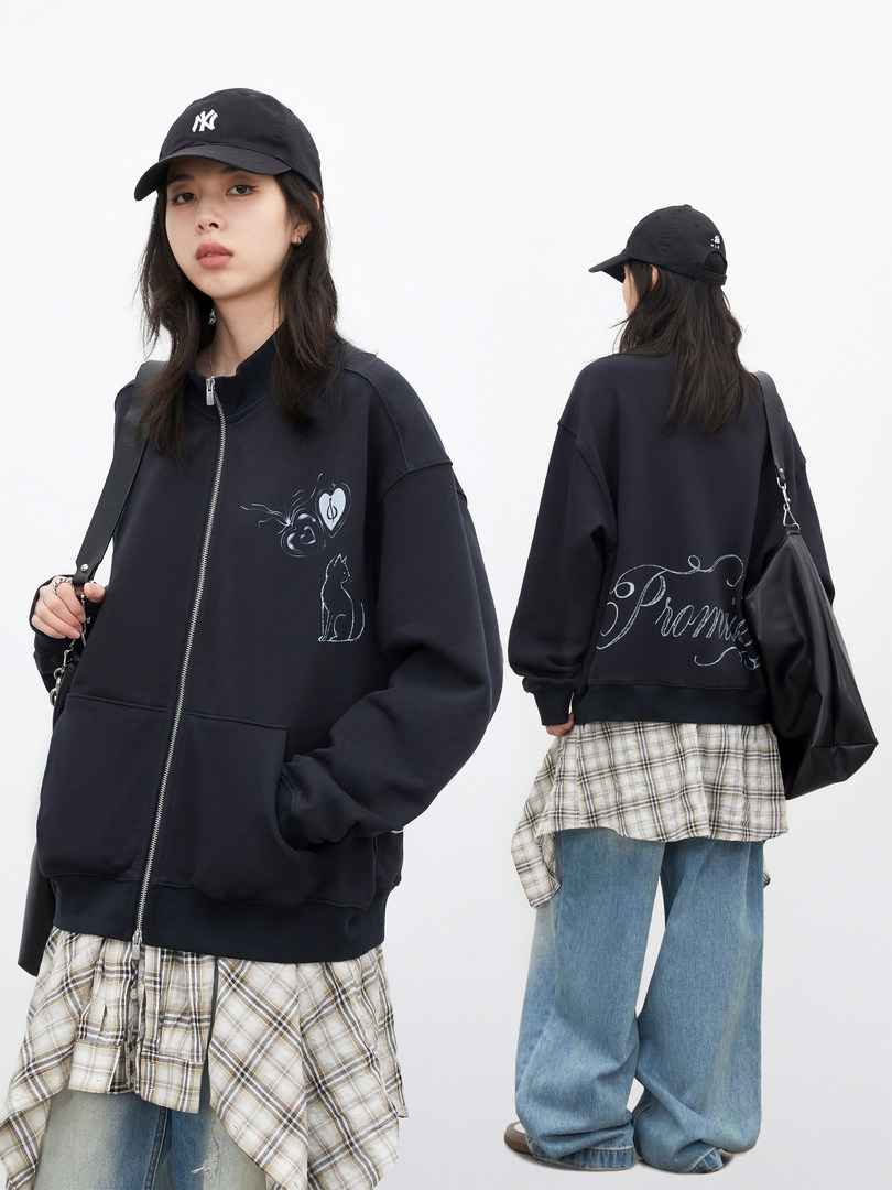 Black oversized zip-up sweatshirt worn by a model, shown front and back with graphic prints