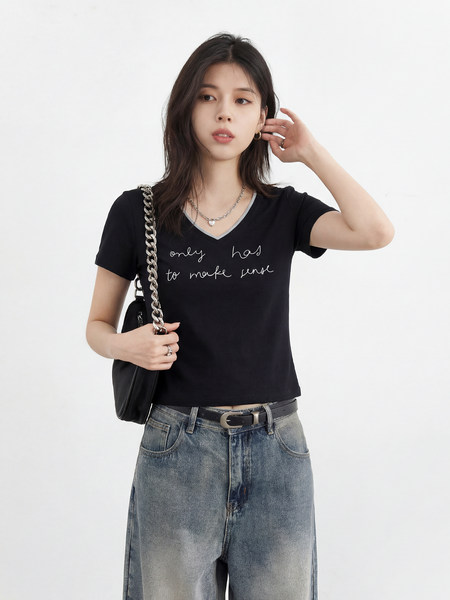 Black V-neck graphic T-shirt worn by a model with jeans and a shoulder bag