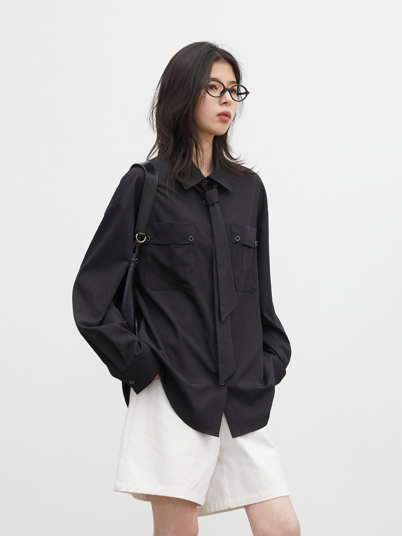 Black oversized button-up shirt worn by a model with white shorts
