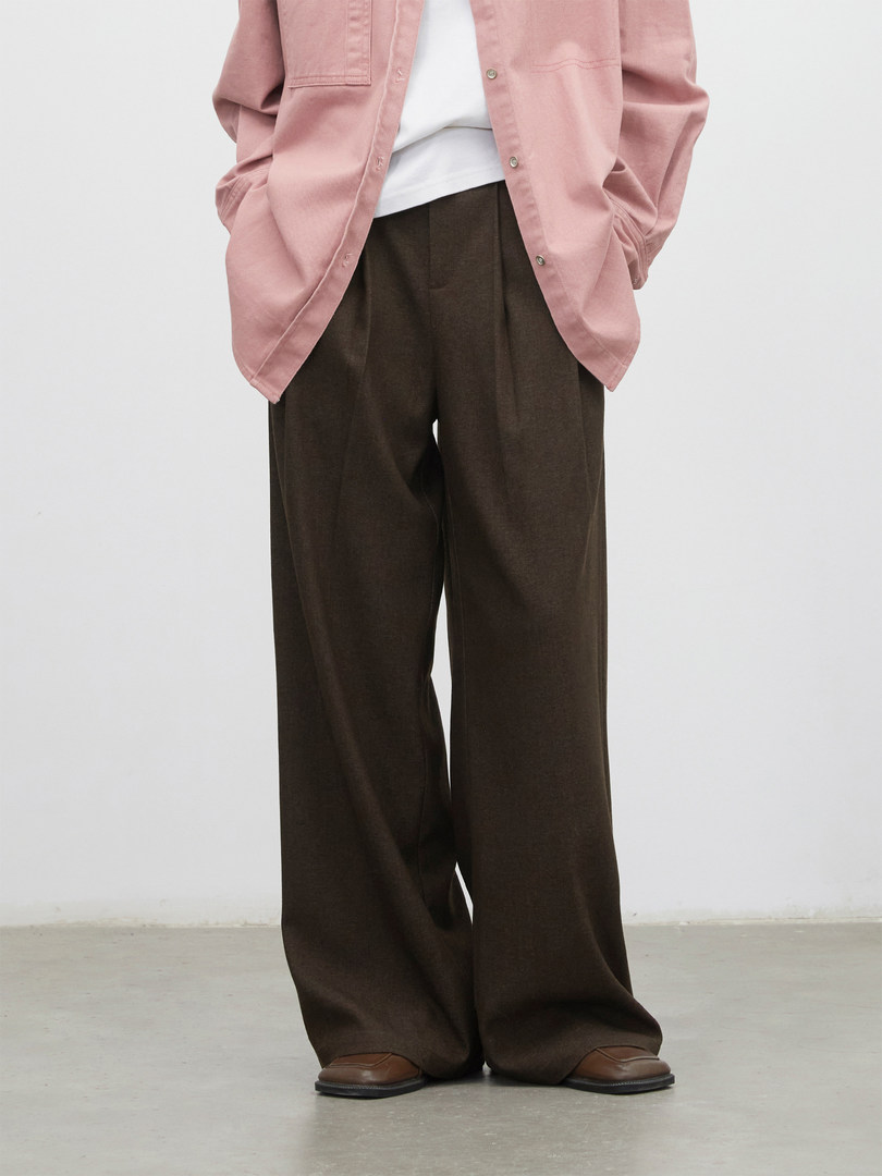 Model wearing wide-leg brown trousers with a pink button-up shirt and brown shoes