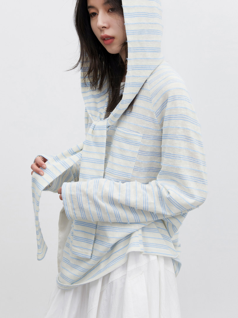 Model wearing a light striped hooded top