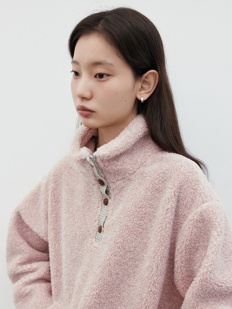 Model wearing a pink fuzzy fleece pullover sweater