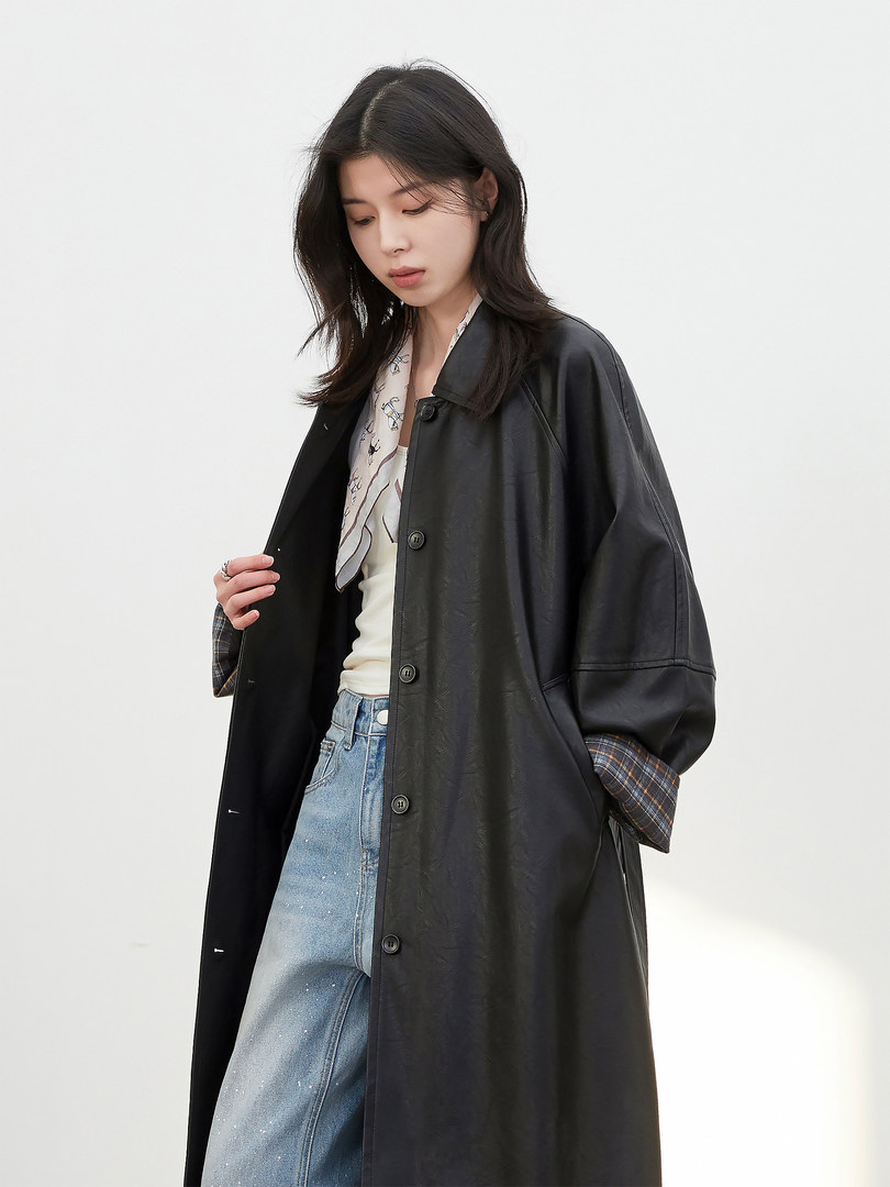 Black long coat worn over a casual outfit on a model