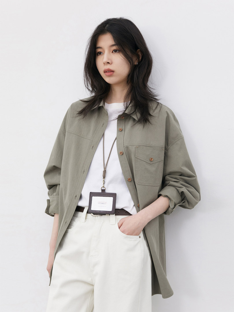 Model wearing an olive oversized button-up shirt with white pants