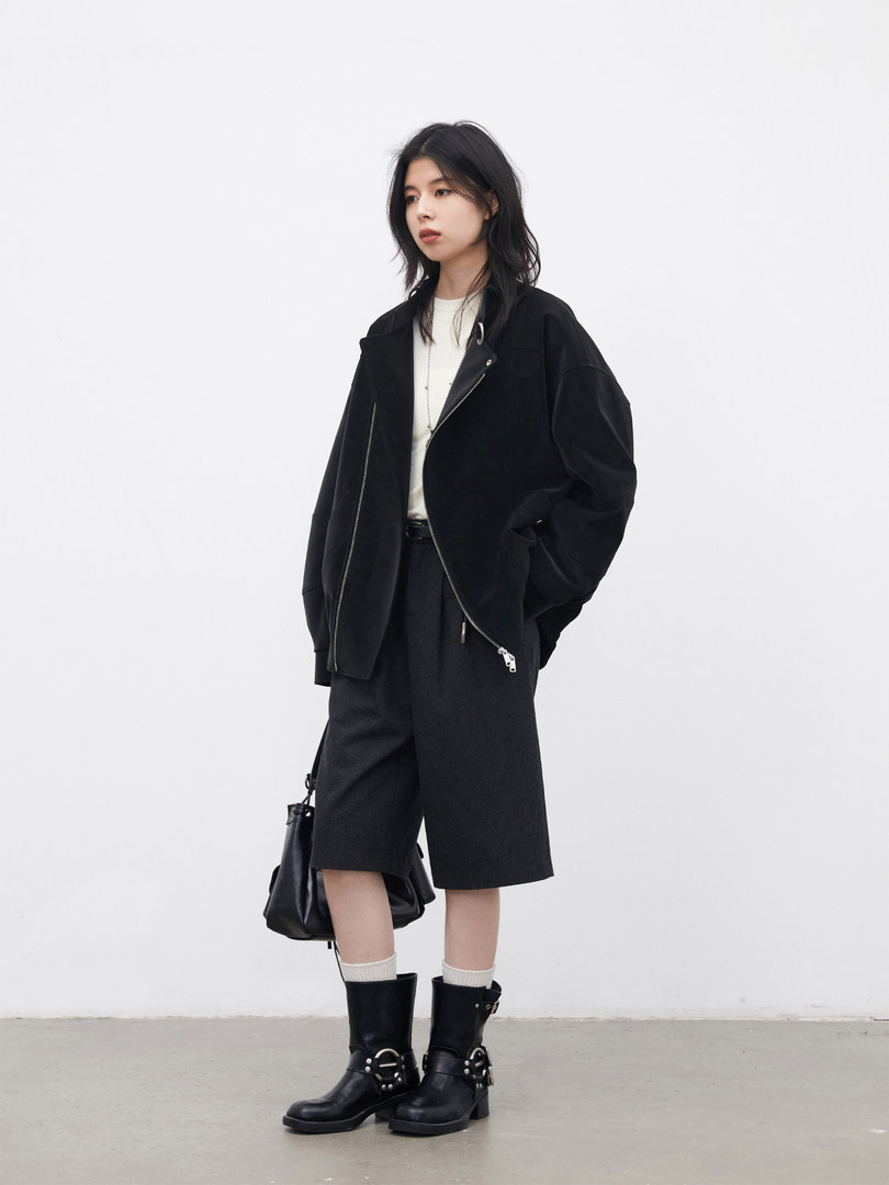 Model wearing a black jacket, shorts, and boots