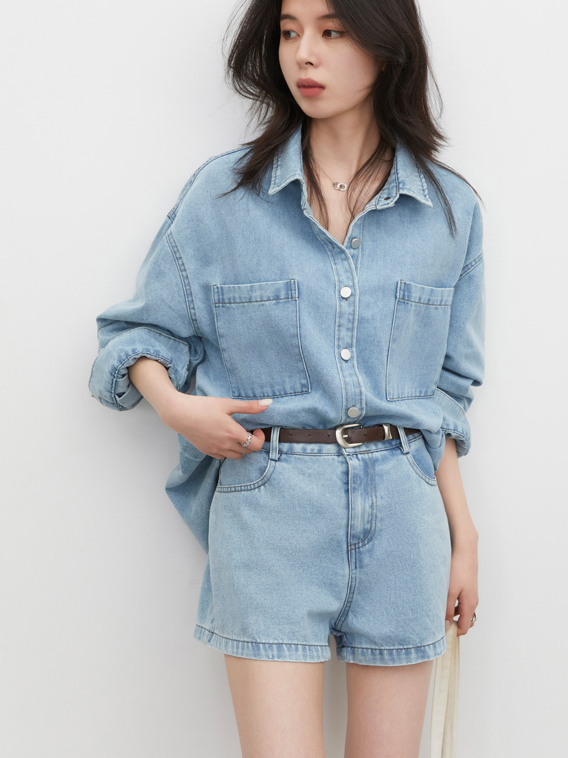 Model wearing a light blue denim shirt and matching denim shorts