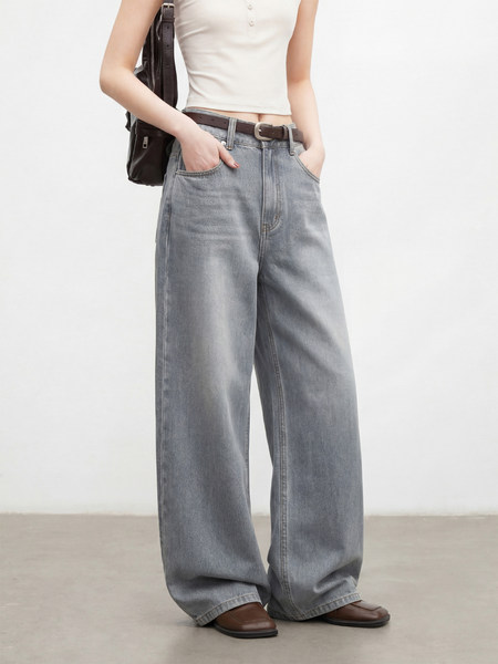 Model wearing wide-leg gray jeans with a white crop top and brown shoes