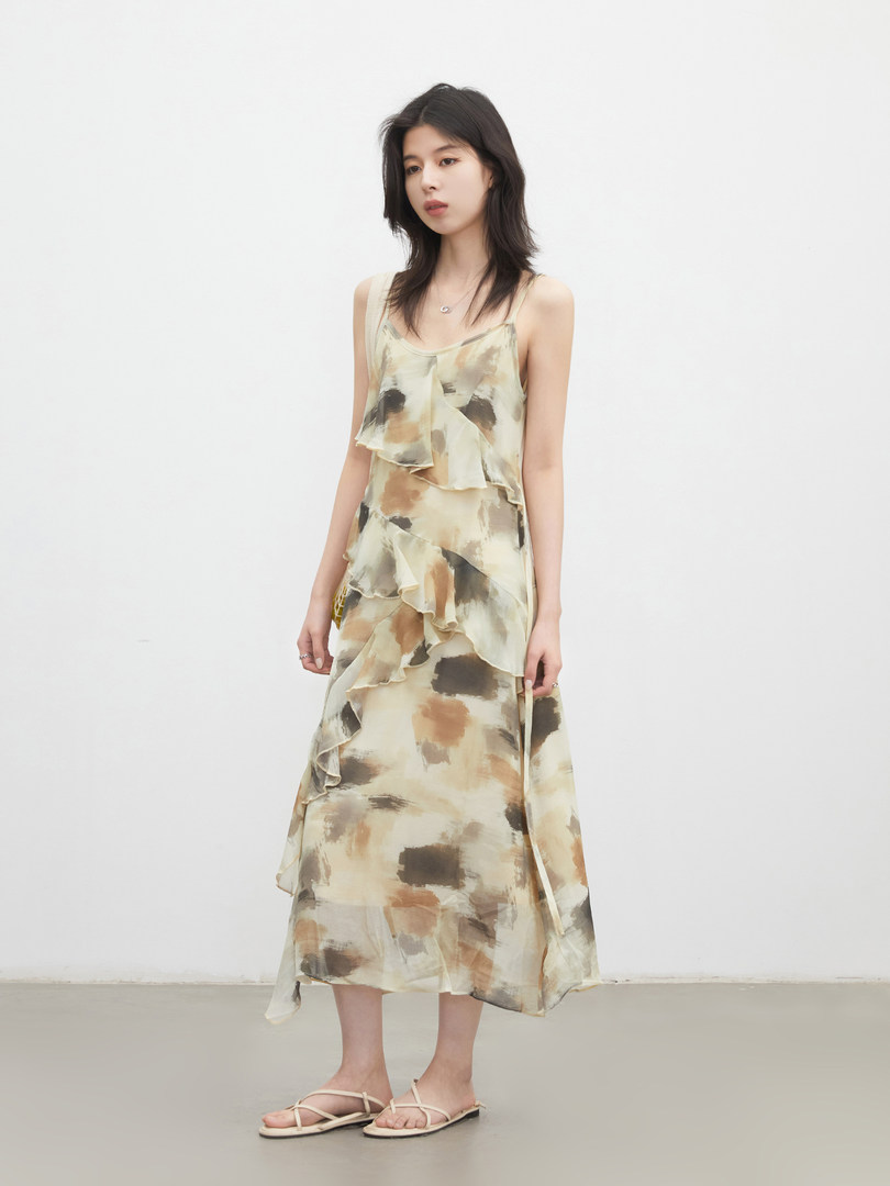Model wearing a sleeveless floral ruffled midi dress and sandals