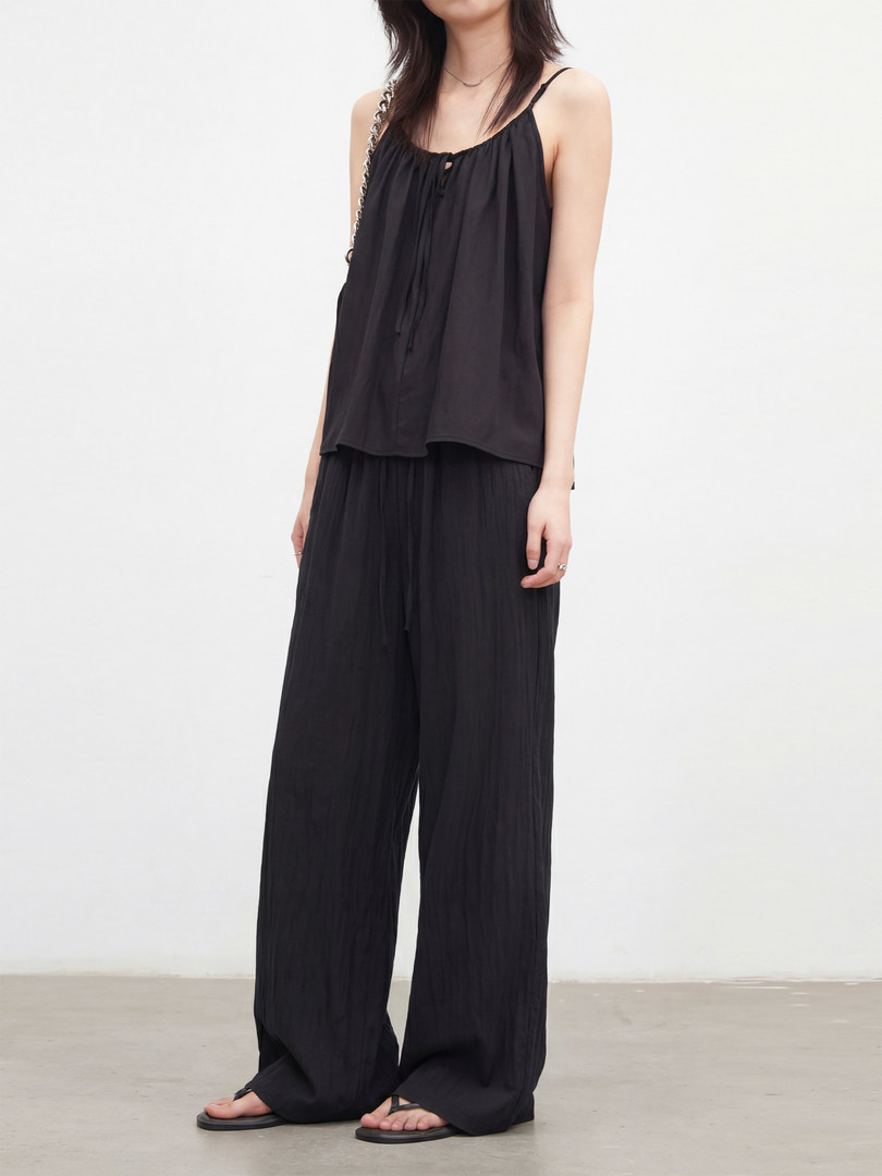 Black sleeveless top and wide-leg pants outfit worn by a model