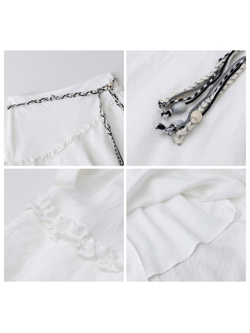 White lace-trimmed garment with braided straps shown in close-up