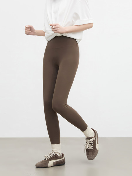 Model wearing brown leggings with sneakers