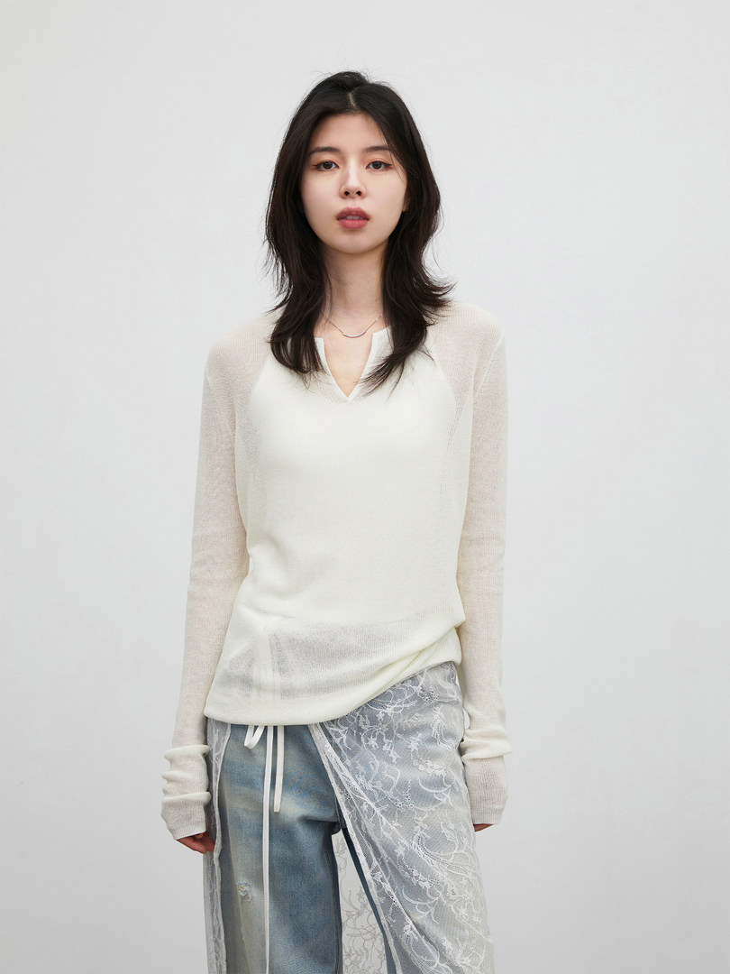 Model wearing a white sheer long-sleeve top with lace overlay and jeans