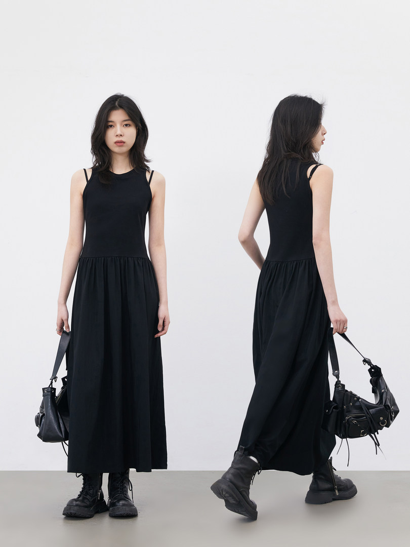 Black sleeveless maxi dress worn by a model with black boots and a handbag