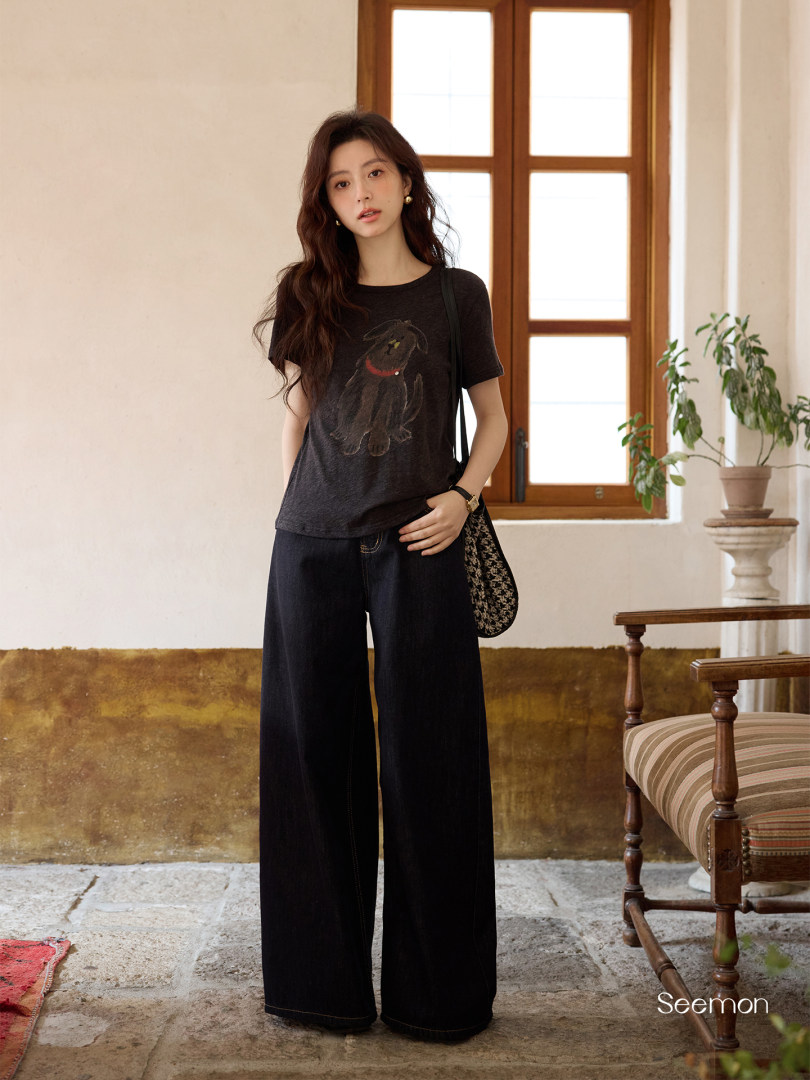 Model wearing a black graphic T-shirt and wide-leg black pants