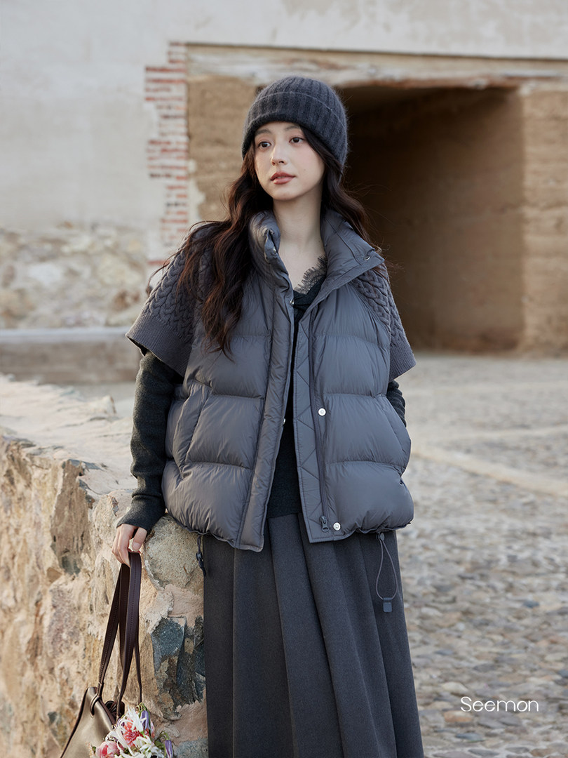 Woman wearing a dark gray puffer vest and winter outfit outdoors