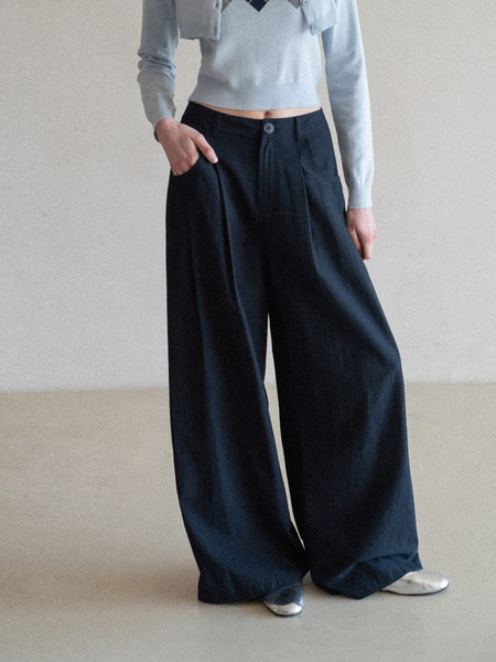 Model wearing wide-leg dark navy pants with a light cropped sweater