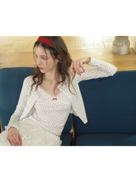 Model wearing a white floral long-sleeve top with matching cardigan and skirt