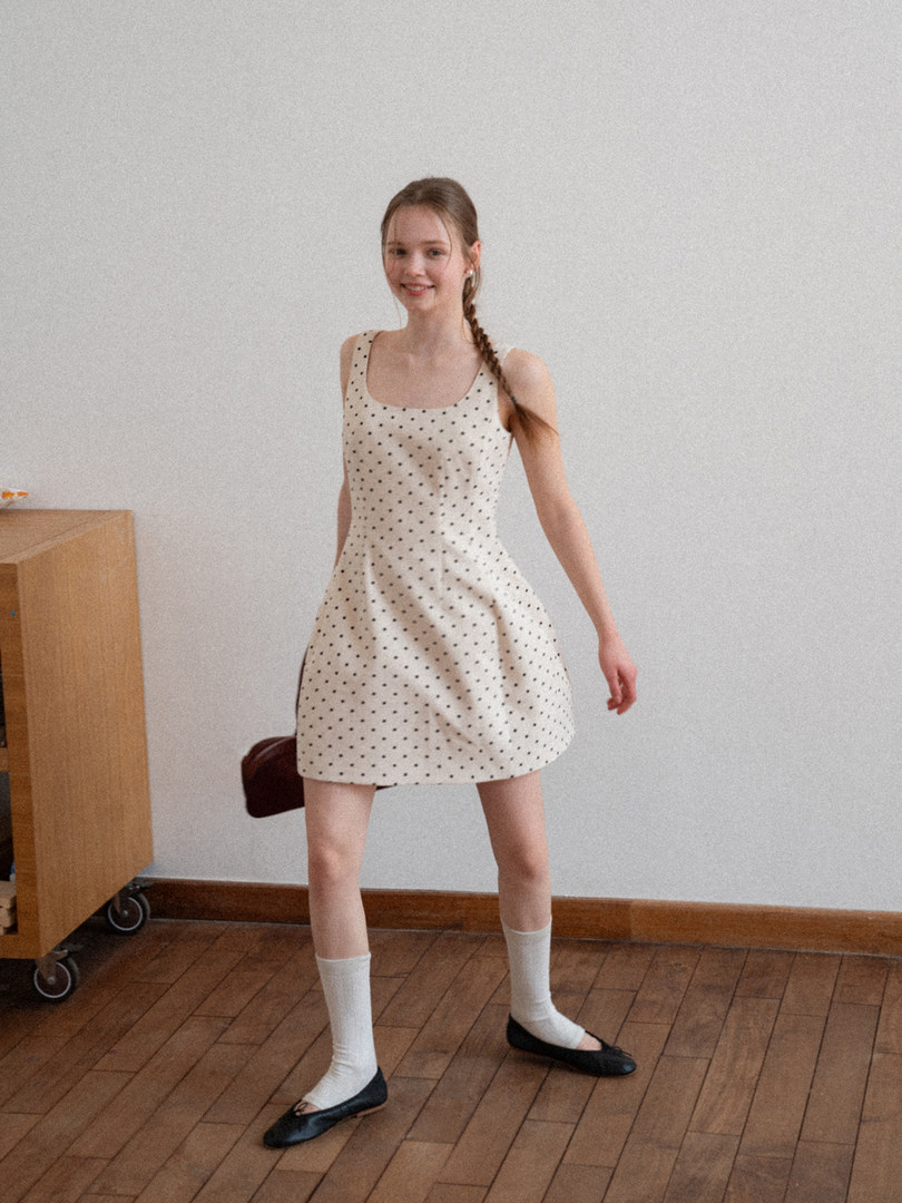 Sleeveless white polka dot dress worn by a model
