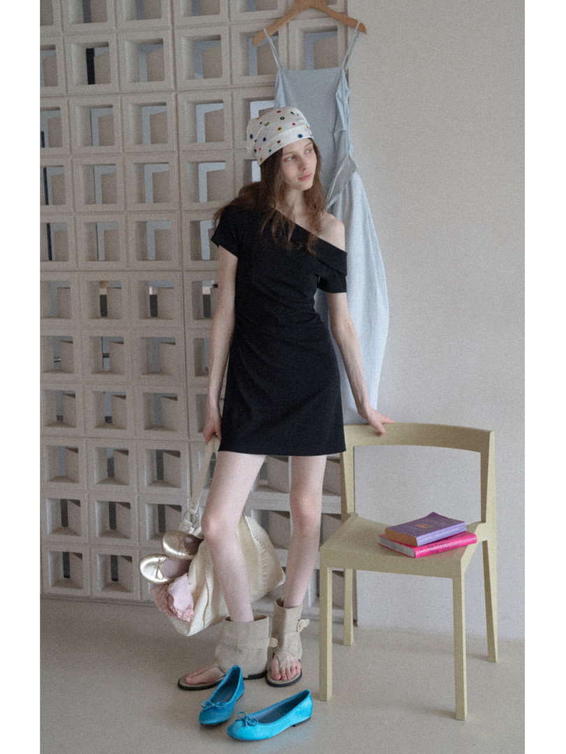 Woman wearing a black off-shoulder mini dress with matching sandals