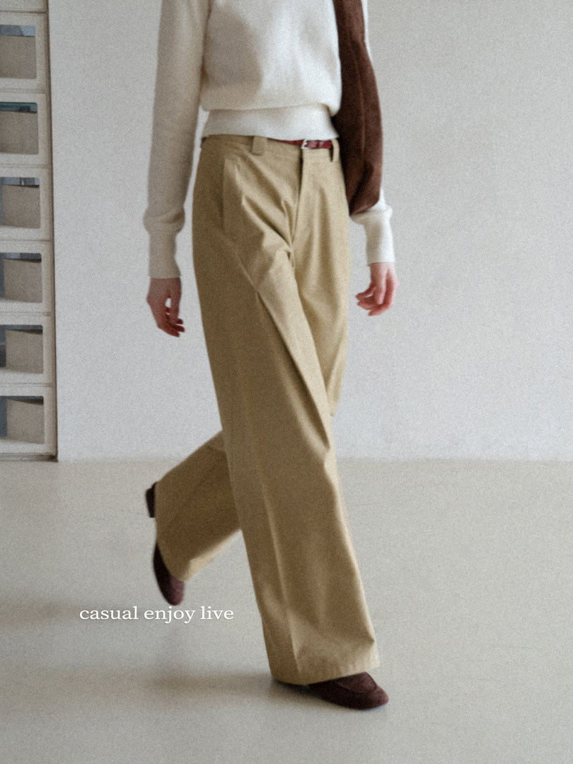 Model wearing beige wide-leg trousers with a white sweater