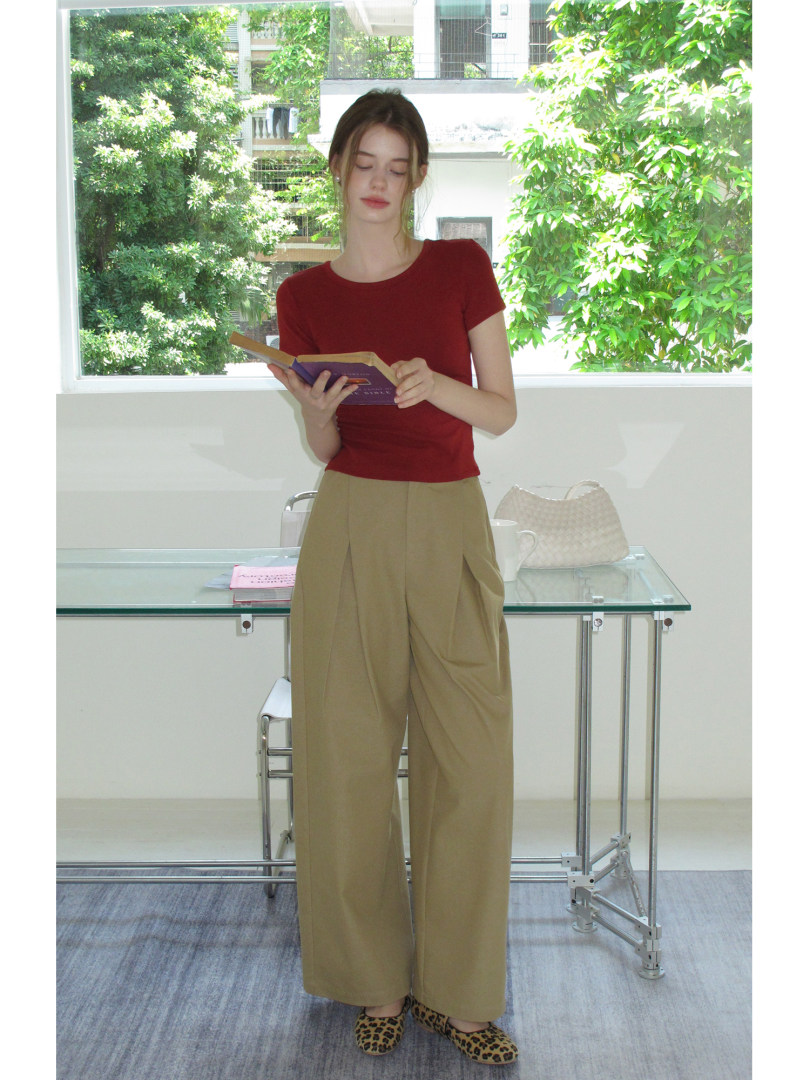 Model wearing a red short-sleeve top with beige wide-leg pants and leopard flats