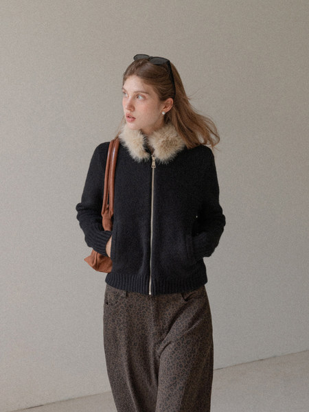 Black zip-up jacket with faux fur collar worn by a model