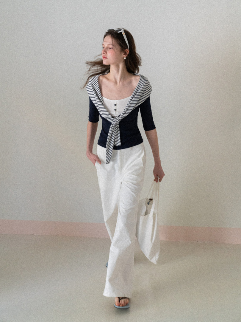 Model wearing a navy and white striped knit top with white wide-leg pants