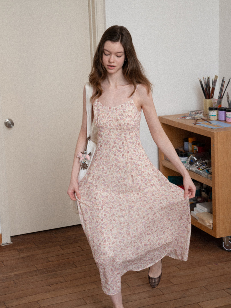 Woman wearing a light pink floral midi dress indoors