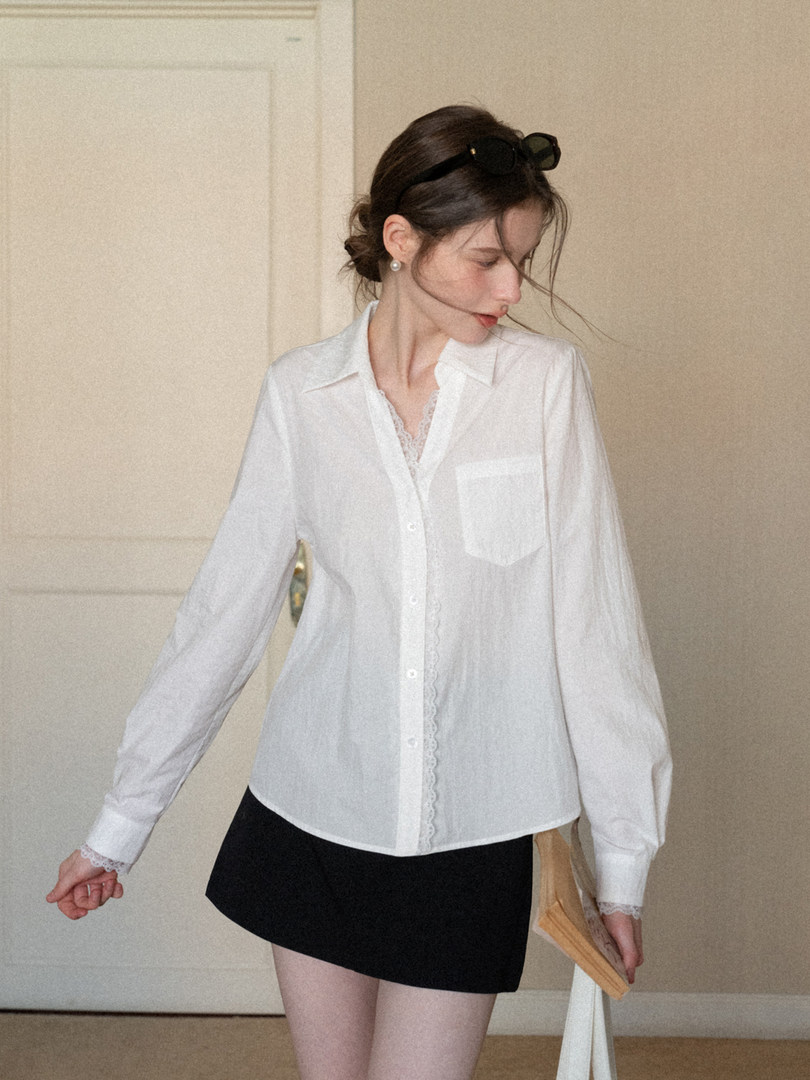 White long-sleeve button-up blouse worn by a model