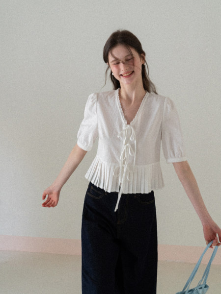White short-sleeve tie-front blouse worn by a model