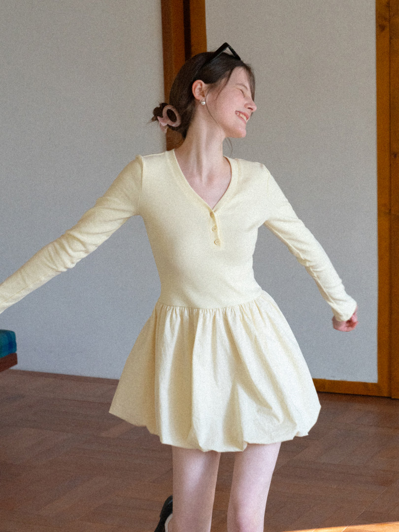 Woman wearing a cream long-sleeve flared dress