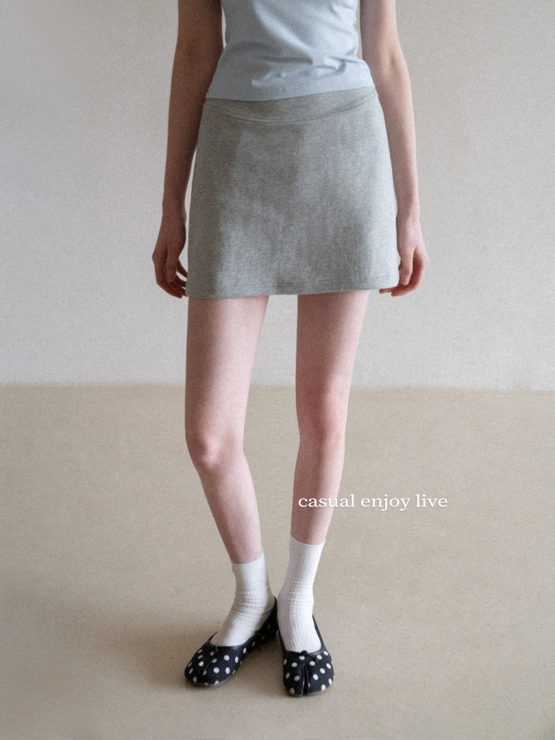 Model wearing a gray mini skirt with a light blue sleeveless top