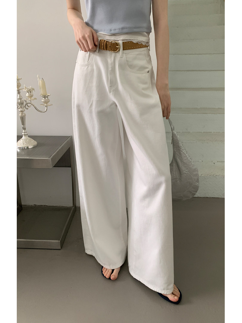White wide-leg pants worn by a model with a brown belt